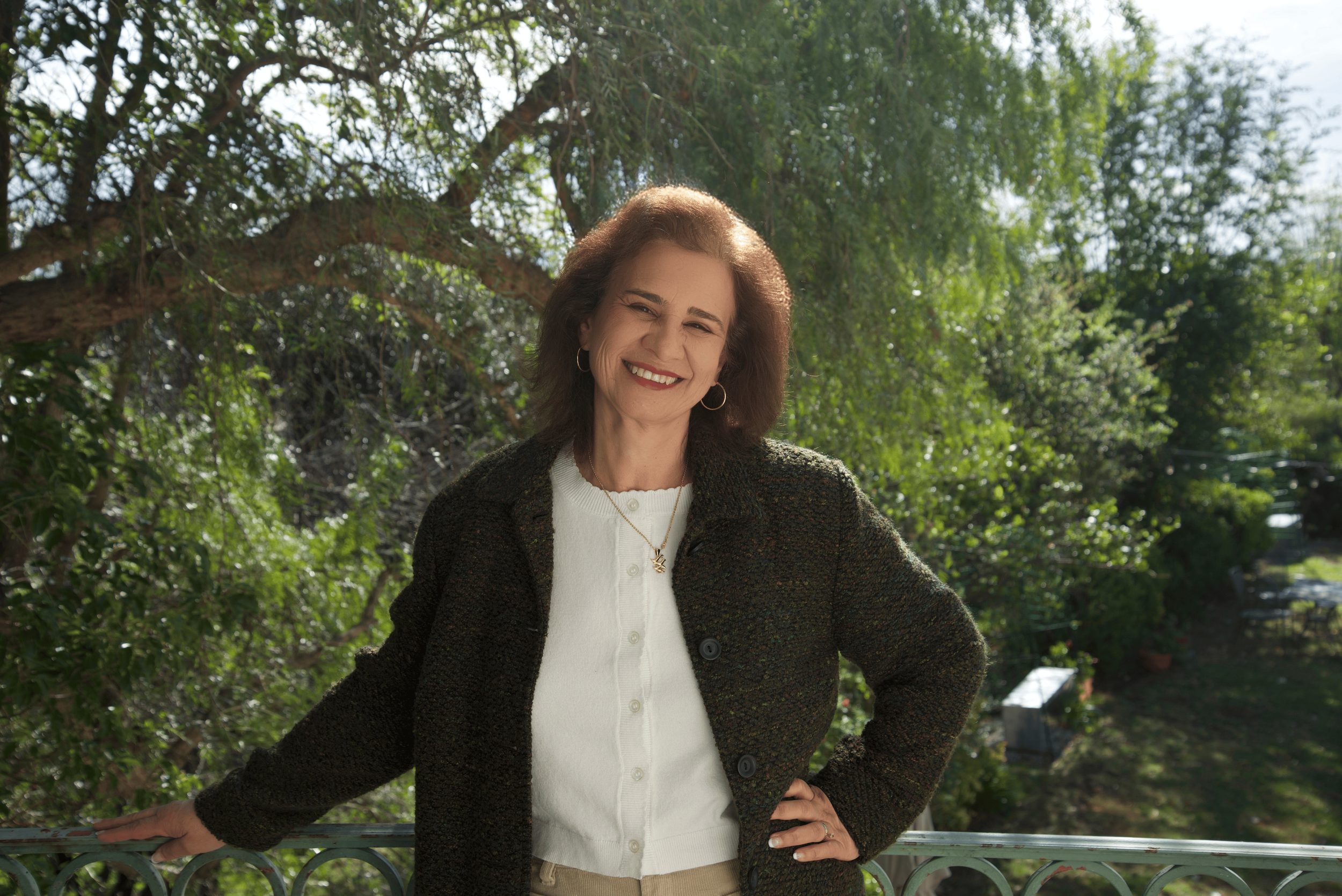 Portrait of a woman with shoulder-length brown hair, smiling, wearing a red top.