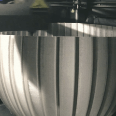 Nahaufnahme eines Metallgefäßes mit vertikalen Einkerbungen.