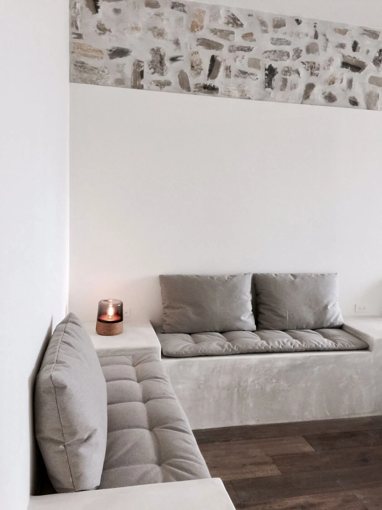 Rachael Goddard Design Studio Calabasas Living room with beige velvet couches, a small white side table with a candle, and a large abstract painting on the wall with earthy tones.