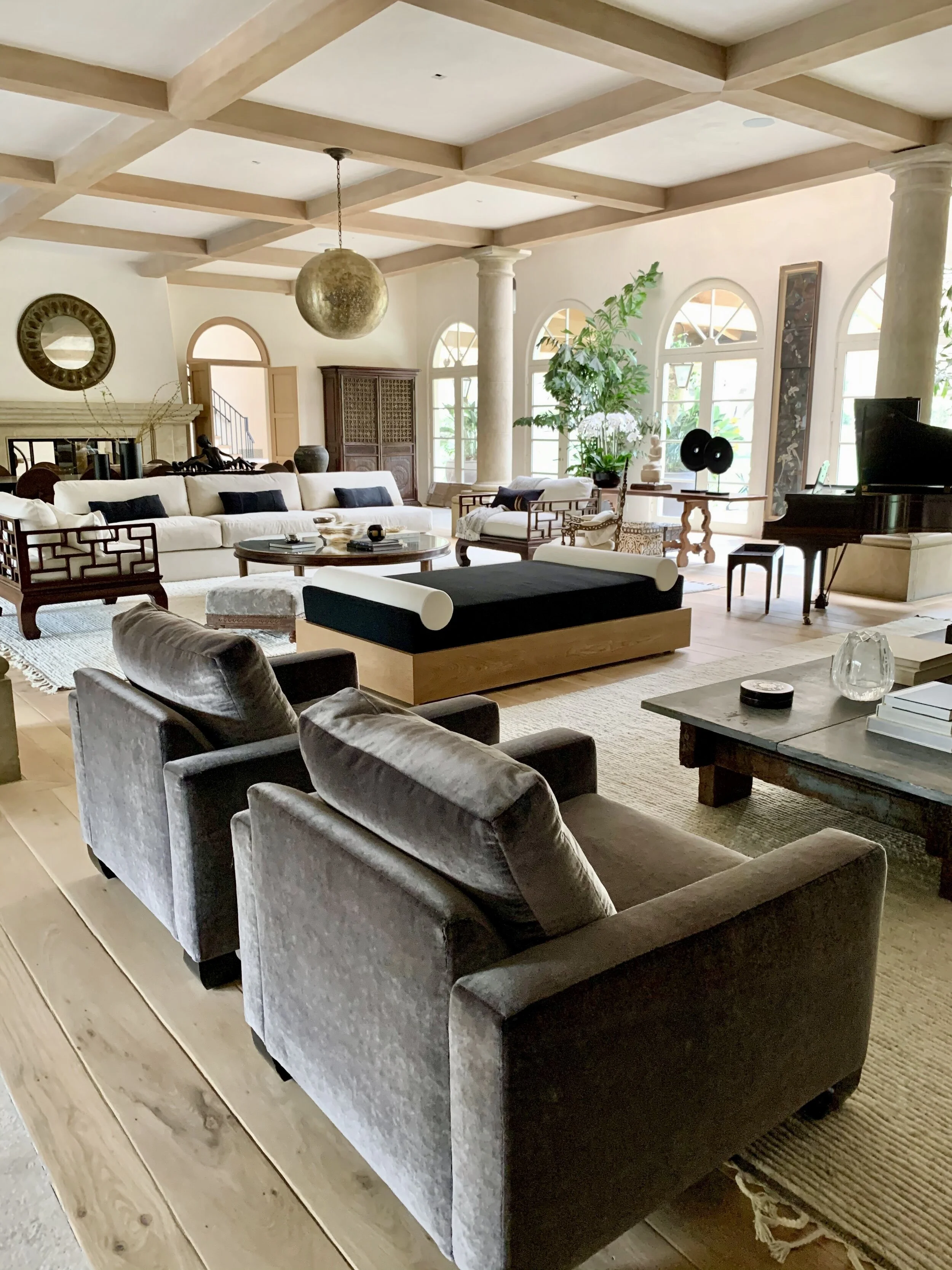 Alt text: Rachael Goddard Design Studio Malibu Retreat spacious living room with arched windows, coffered ceiling, white sectional, and luxury Malibu home design.
