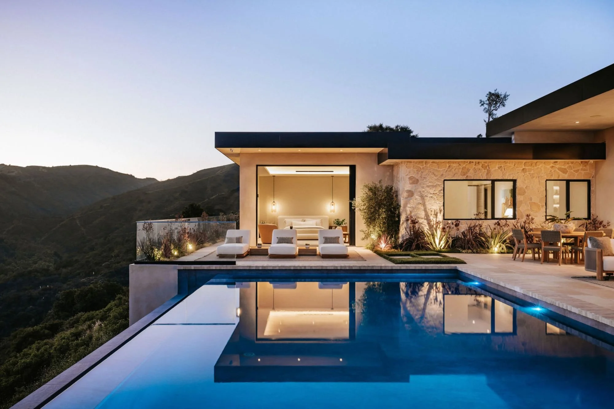 Rachael Goddard Design Studio Calabasas Modern house with outdoor pool, lounge chairs, and patio dining area overlooking mountains at dusk.