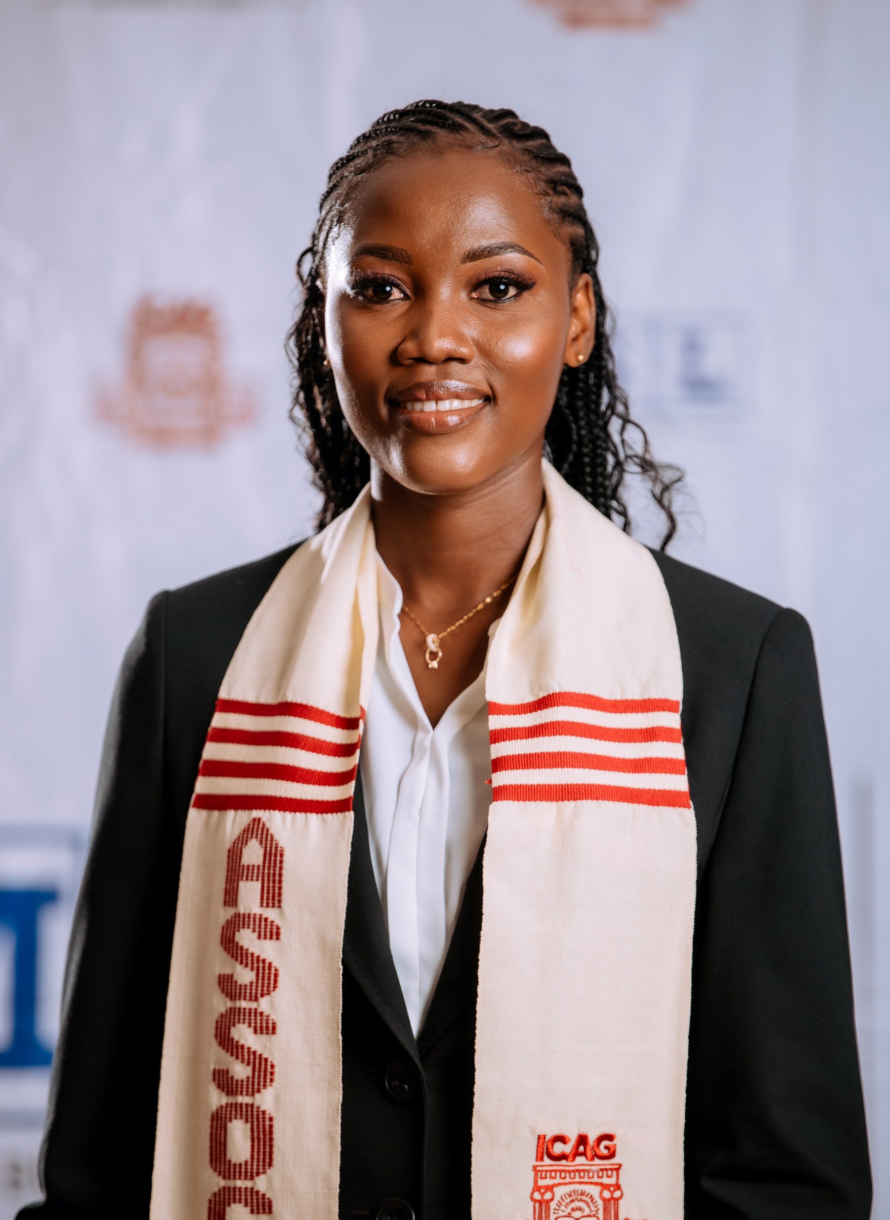 Portrait of a graduate with braided hair wearing a cream ICAG stole, ICAG graduation, September 2025.