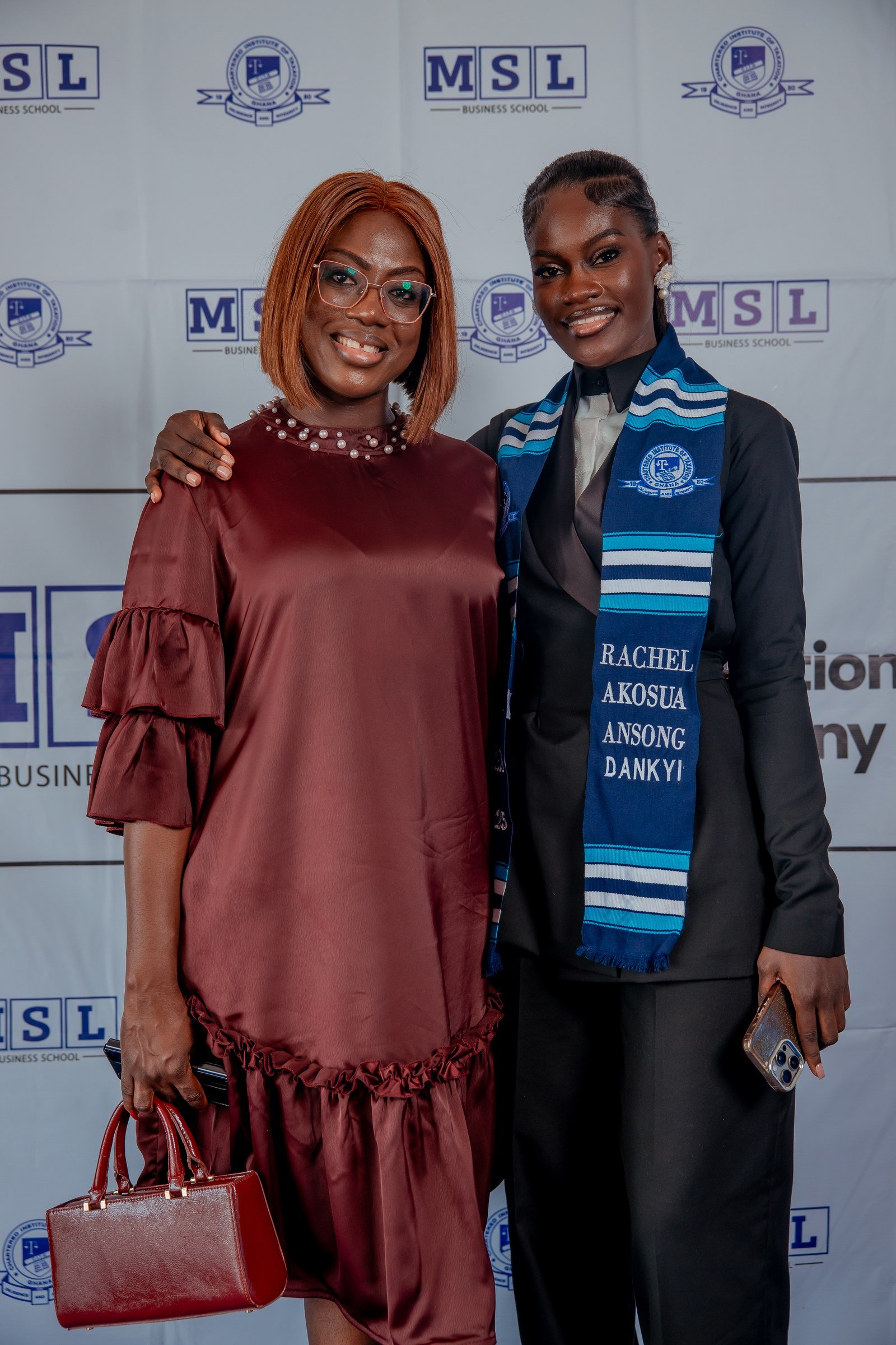 Smiling CITG graduate posing with a supporter in a burgundy dress, CITG graduation, December 2025.