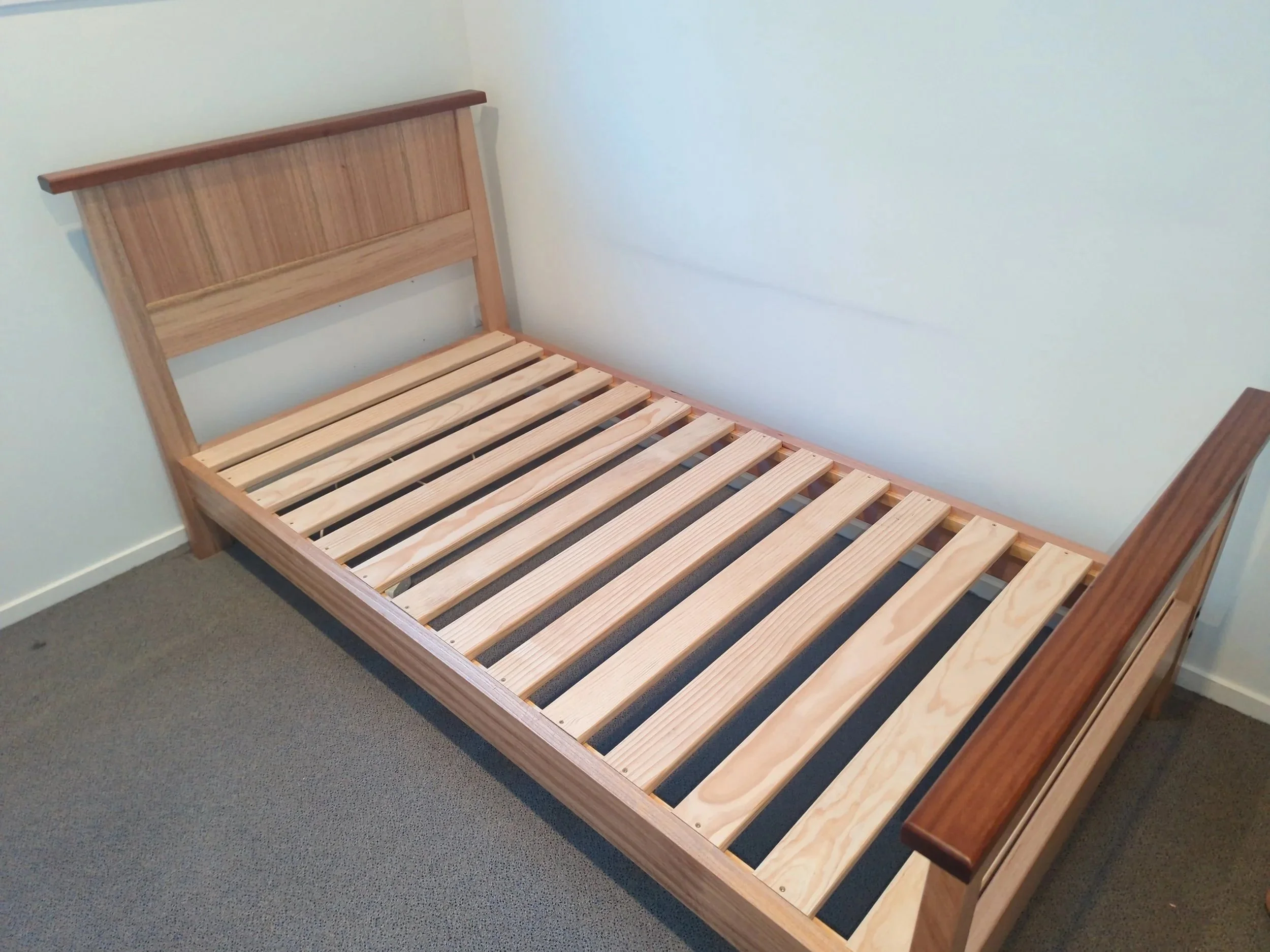 Custom-made Tasmanian oak and mahogany single bed frame handcrafted by Benchman Designs in Queenstown, New Zealand. Bespoke solid timber bed with external fixings, suitable for elderly clients, custom furniture projects, and made-to-order wooden bedr