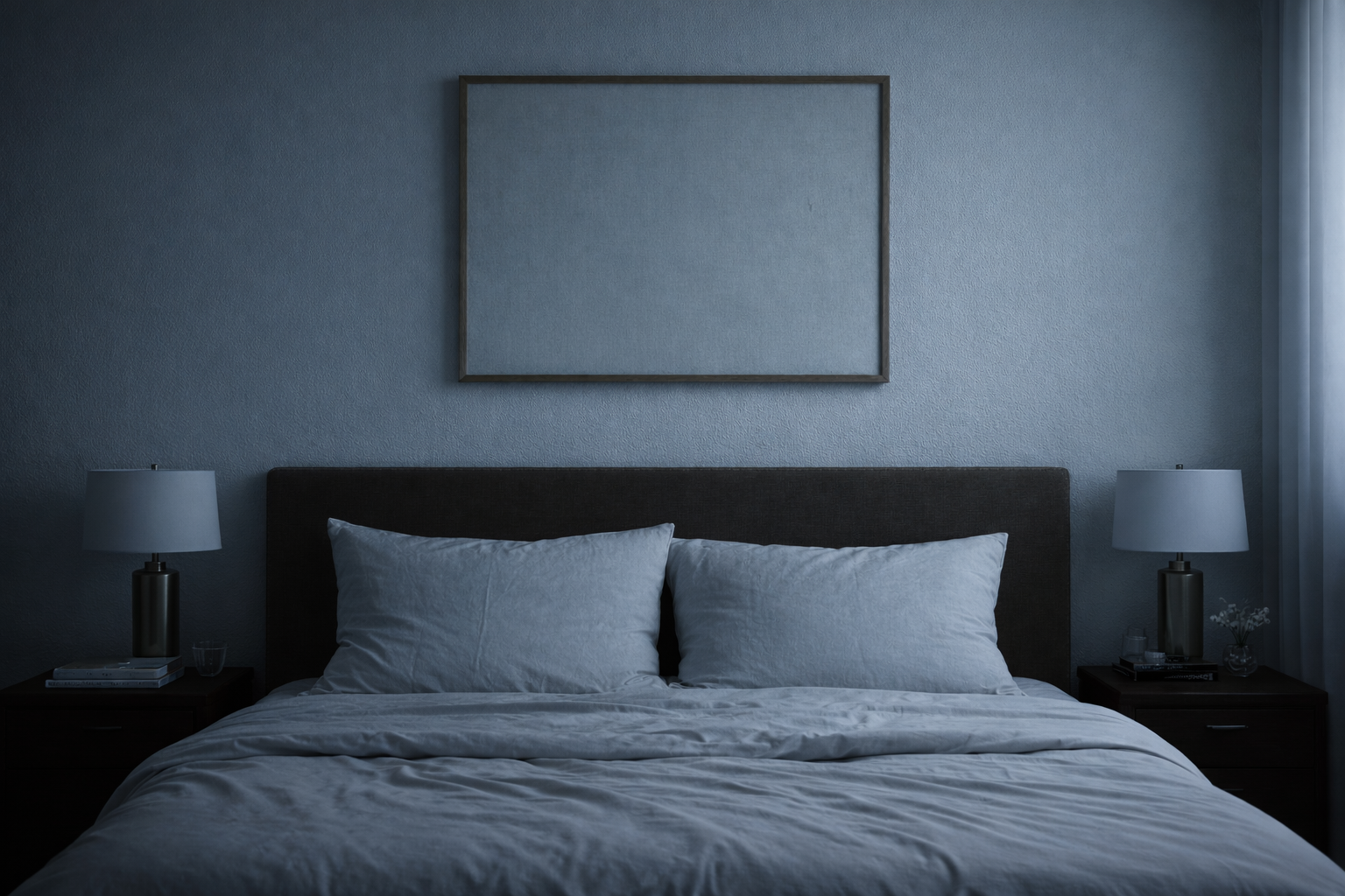 A serene modern bedroom with neutral bedding, matching bedside tables and lamps, and an empty rectangular frame hanging above the headboard, styled softly with cool lighting.