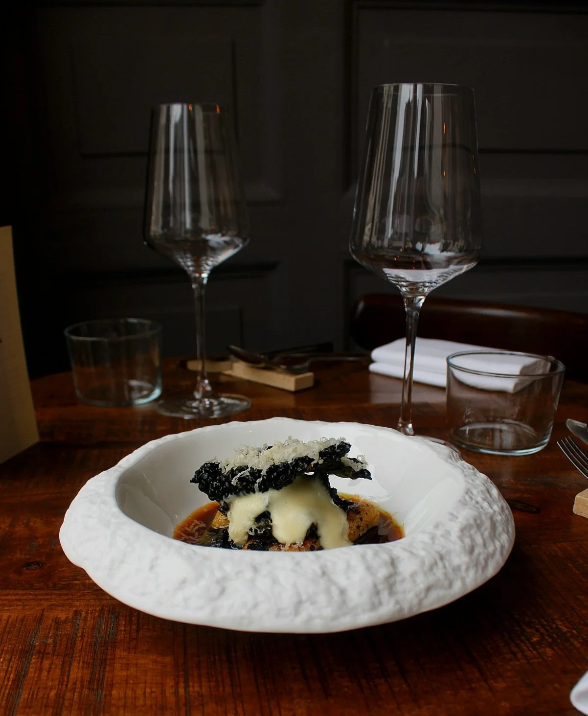 Gerecht met gnocchi, uien bouillon, schuim van aardappel, krokante palmkool