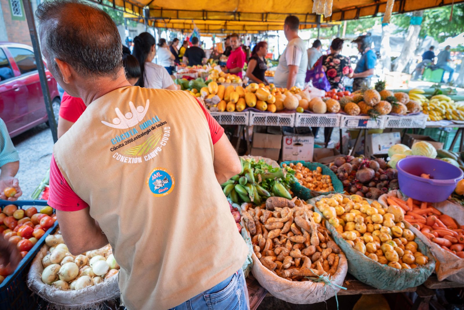 COLOMBIA 2023. Public accountability campaign of the Cúcuta municipal administration.

20 December 2023. Mercado Público de San Luis, Cúcuta, Norte de Santander, Colombia. A vendor wearing a vest from the municipal "Cúcuta Rural - Conexión Campo-Ciud