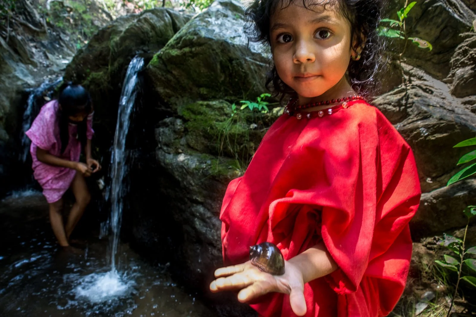 COLOMBIA 2017. Wayuu children in the Macuira mountain range, La Guajira.

23 February 2017. Macuira National Natural Park, La Guajira, Colombia. Two Wayuu girls search for freshwater snails in a stream of the Macuira mountain range, a rare water sour