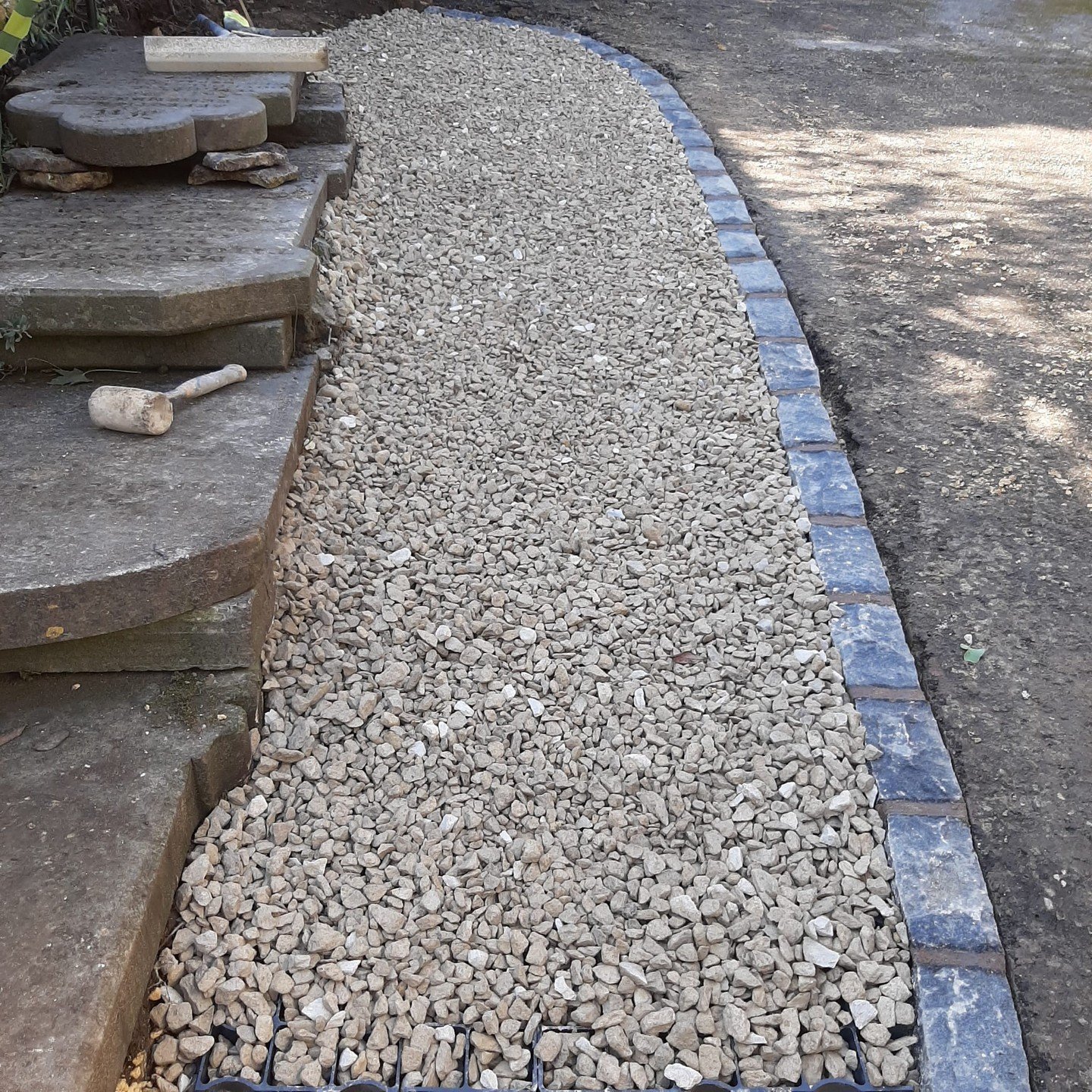 A distinctive driveway project involving the installation of gravel grids, premium gravel, and blue brick edgers. The property is listed, necessitating a refined approach to the driveway pathway.