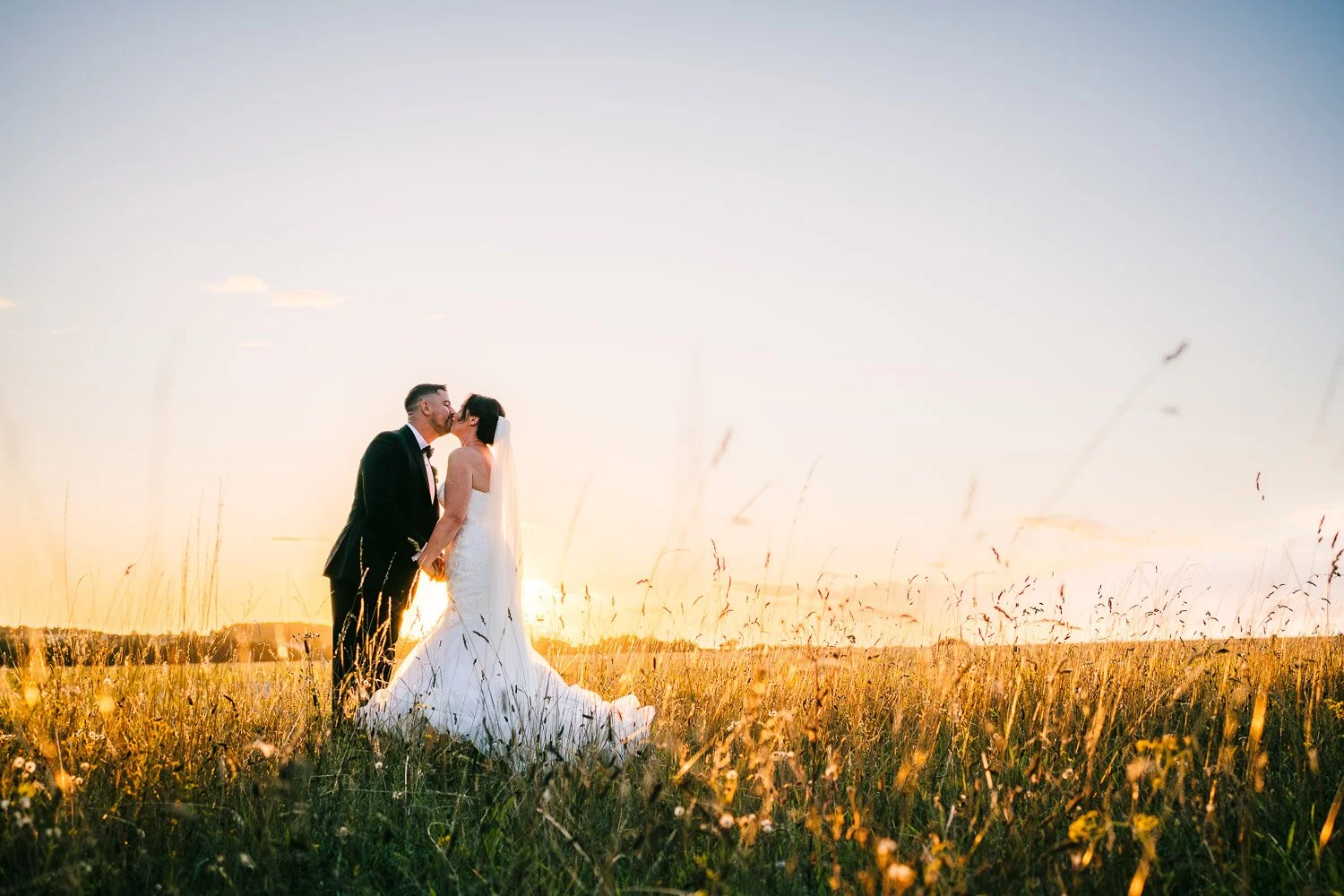 clock-barn-berkshire-wedding-bride-and-groom-kissing-at-sunset.jpg