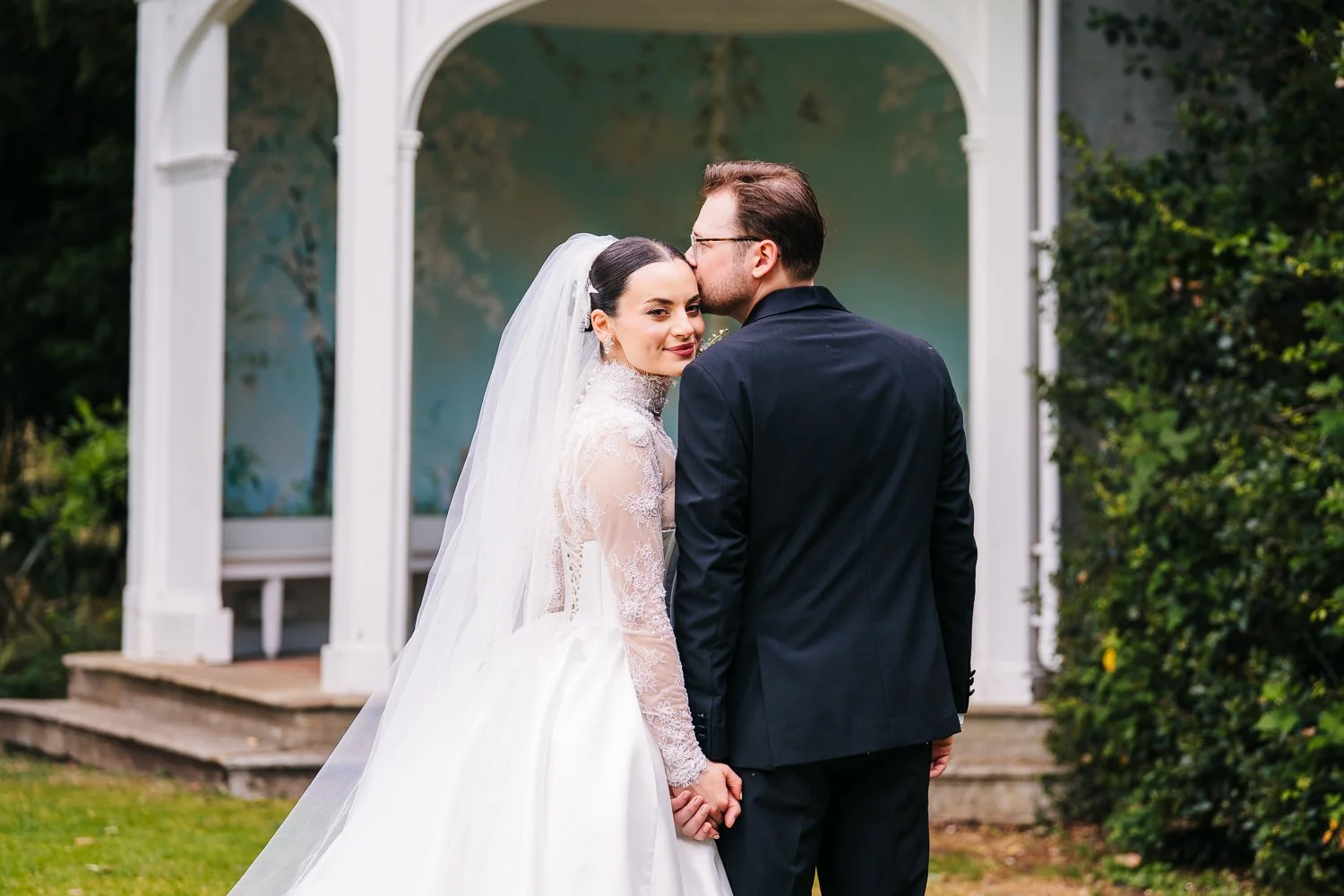 wasing-park-wedding-groom-kissing-brides-forehead-whilst-bride-looks-at-camera.jpg