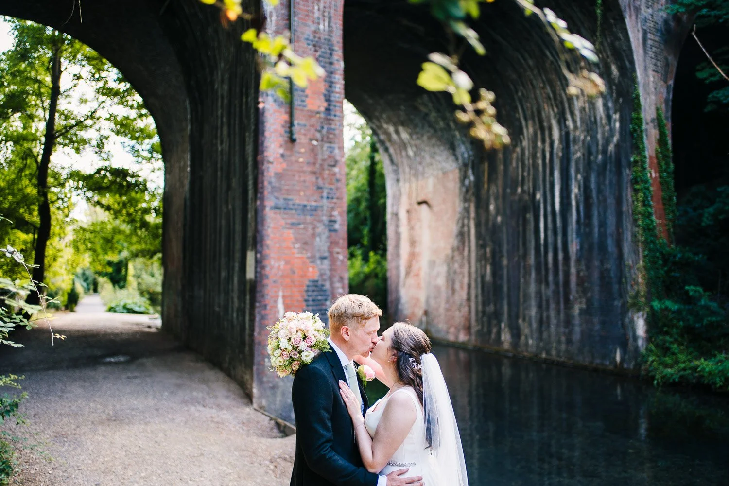 bartons-mill-wedding-kissing-under-the-bridge.jpg