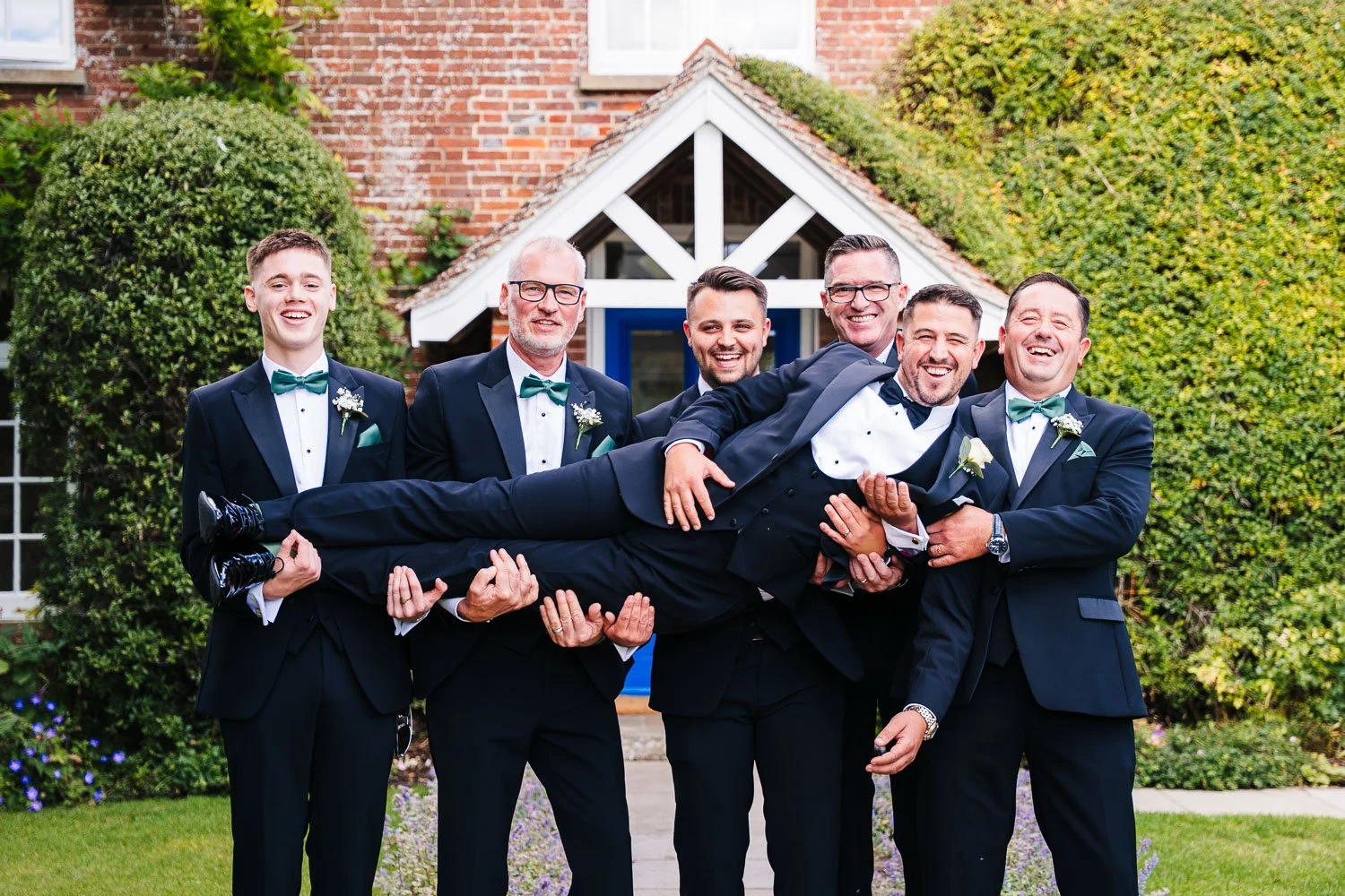 clock-barn-berkshire-groomsmen-lifting-groom.jpg