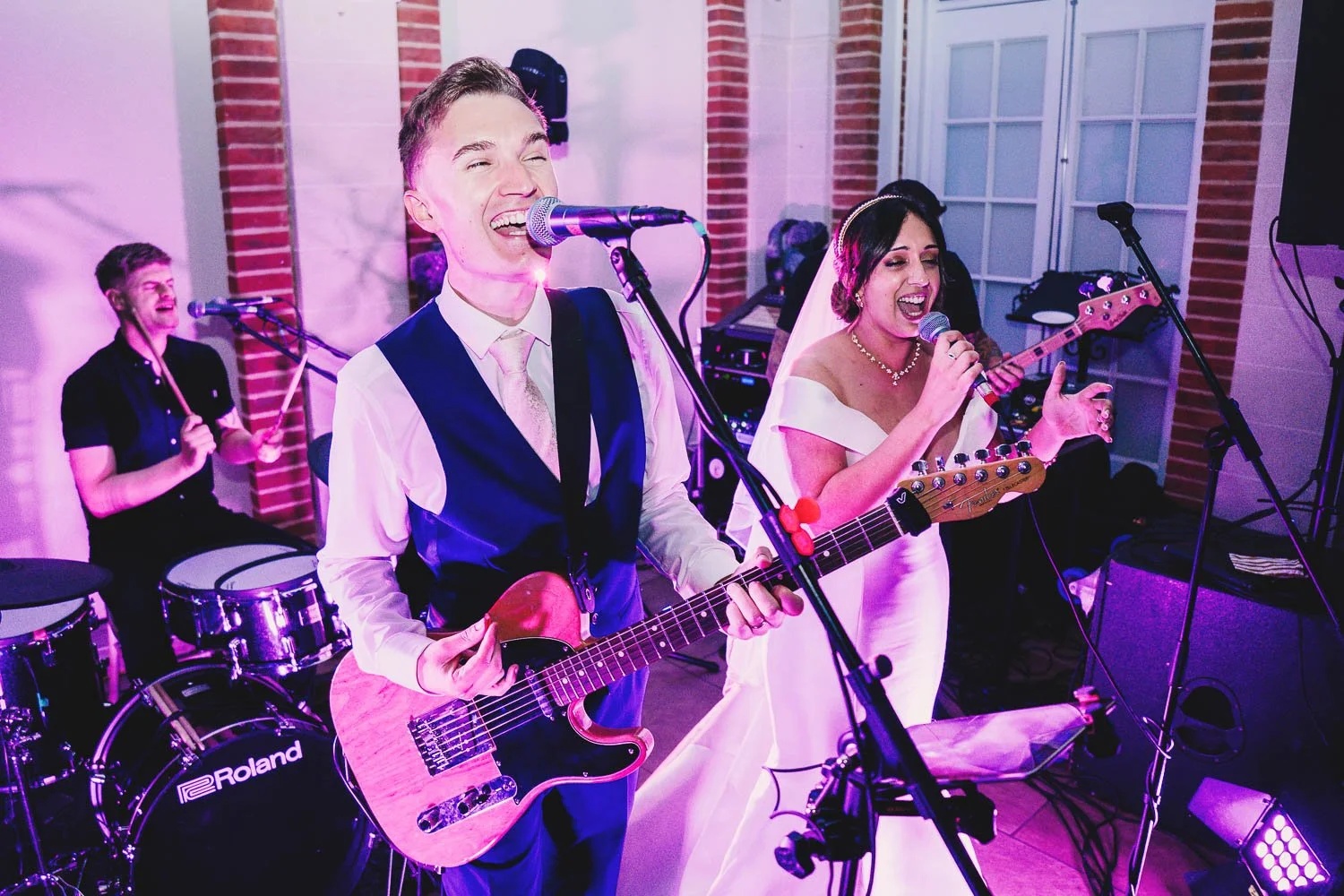 bride-and-groom-playing-guitar-and-singing-at-their-great-fosters-wedding.jpg