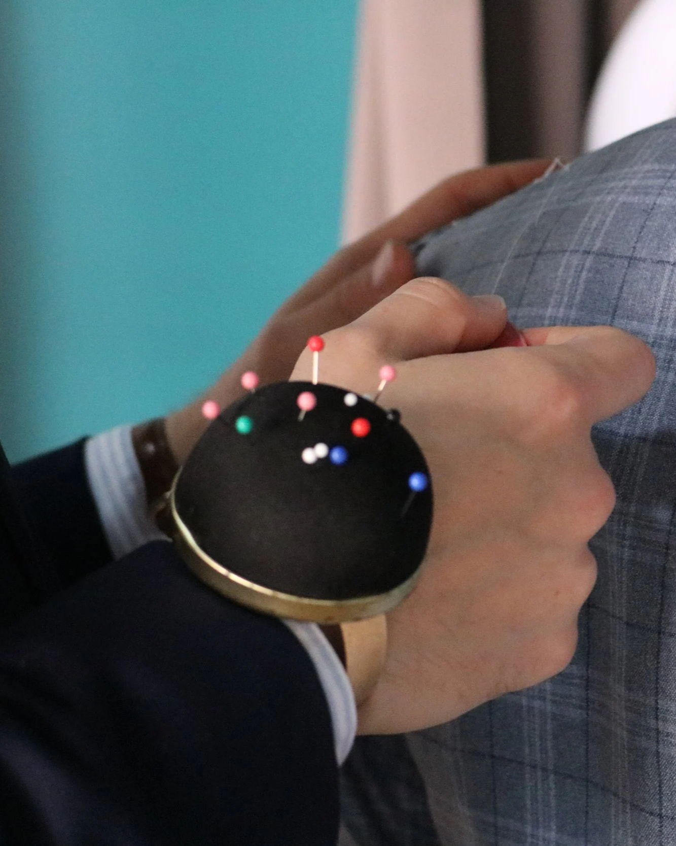 Berez tailor is using pins and chalk to assess changes on a garment.