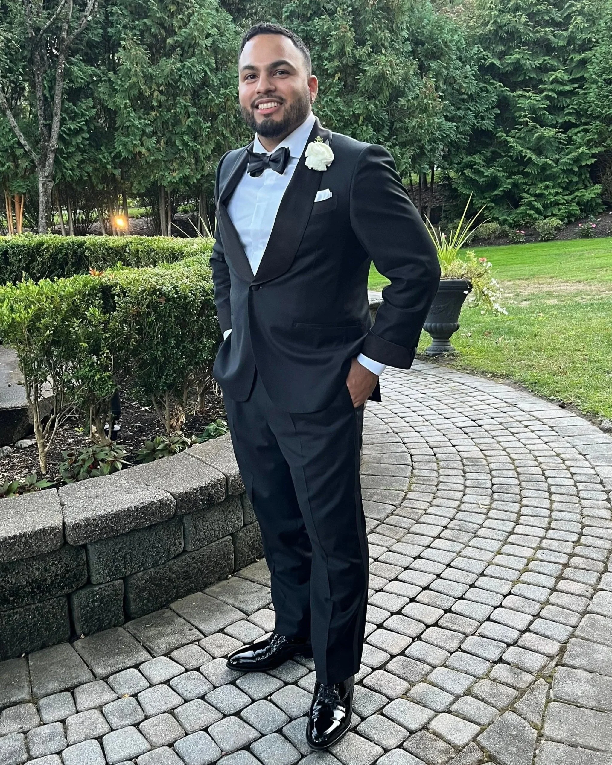 Jeff Ramirez in a black shawl collar tuxedo in a garden