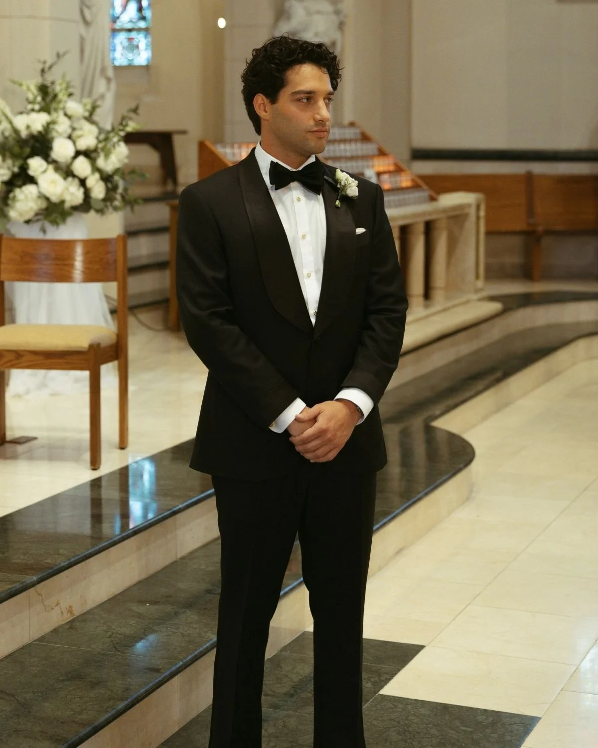 Matt Oristanio in a black shawl collar tuxedo at the altar