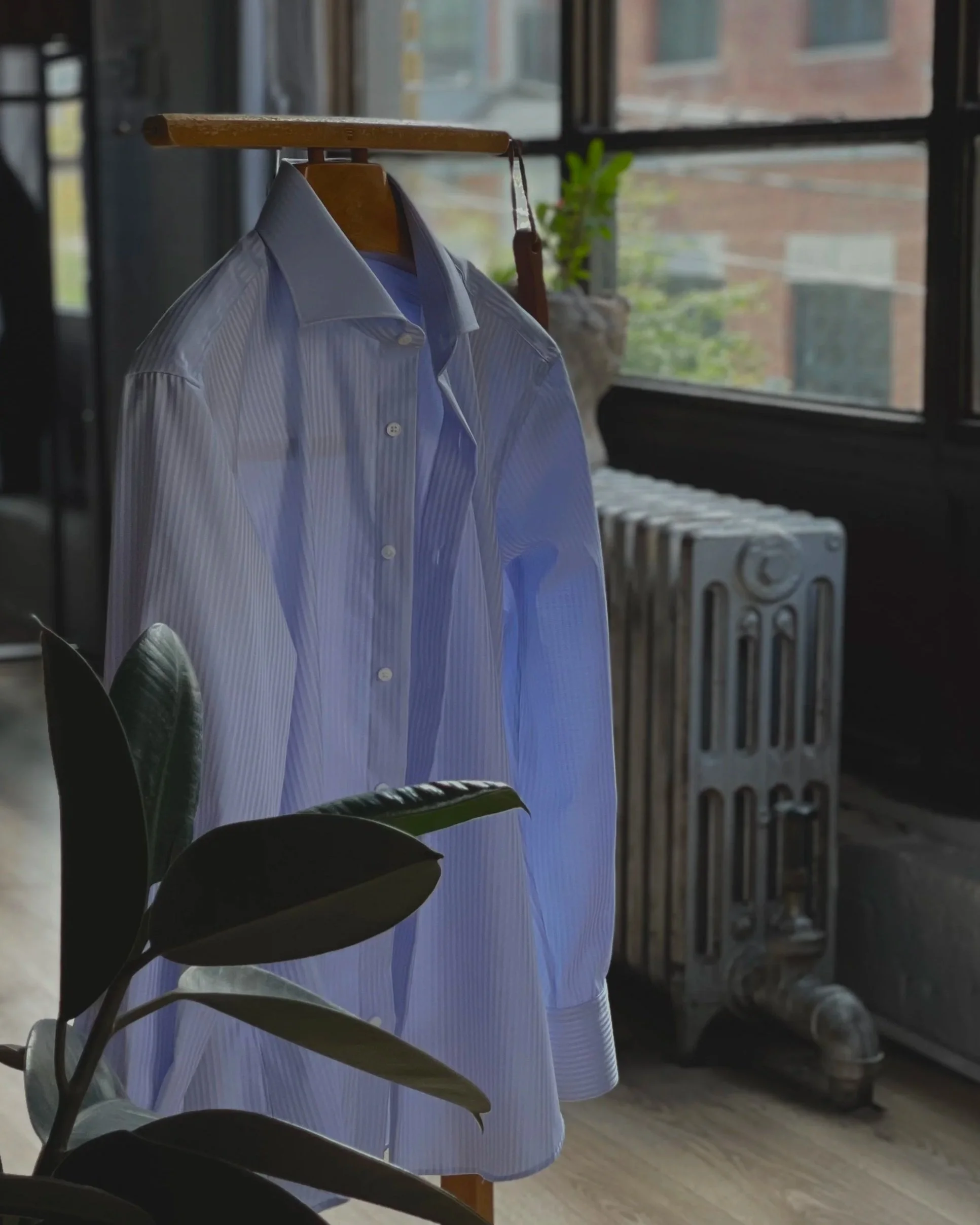 Striped dress shirt with a wide spread collar on a wooden valet stand