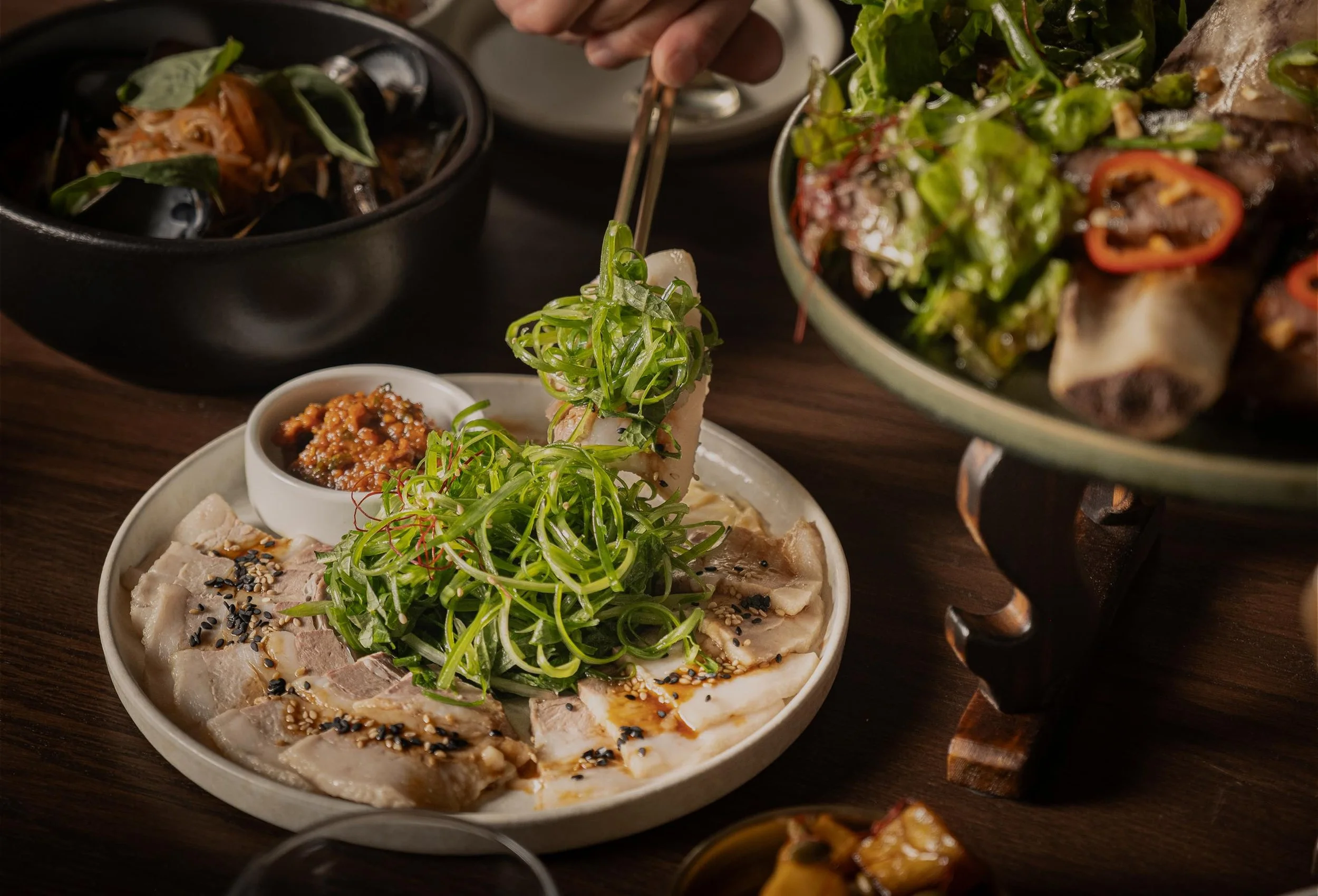 Close-up of a Korean-style shared dish with sliced meat, scallions, and dipping sauce at Hojokban in the Arts District, Downtown LA