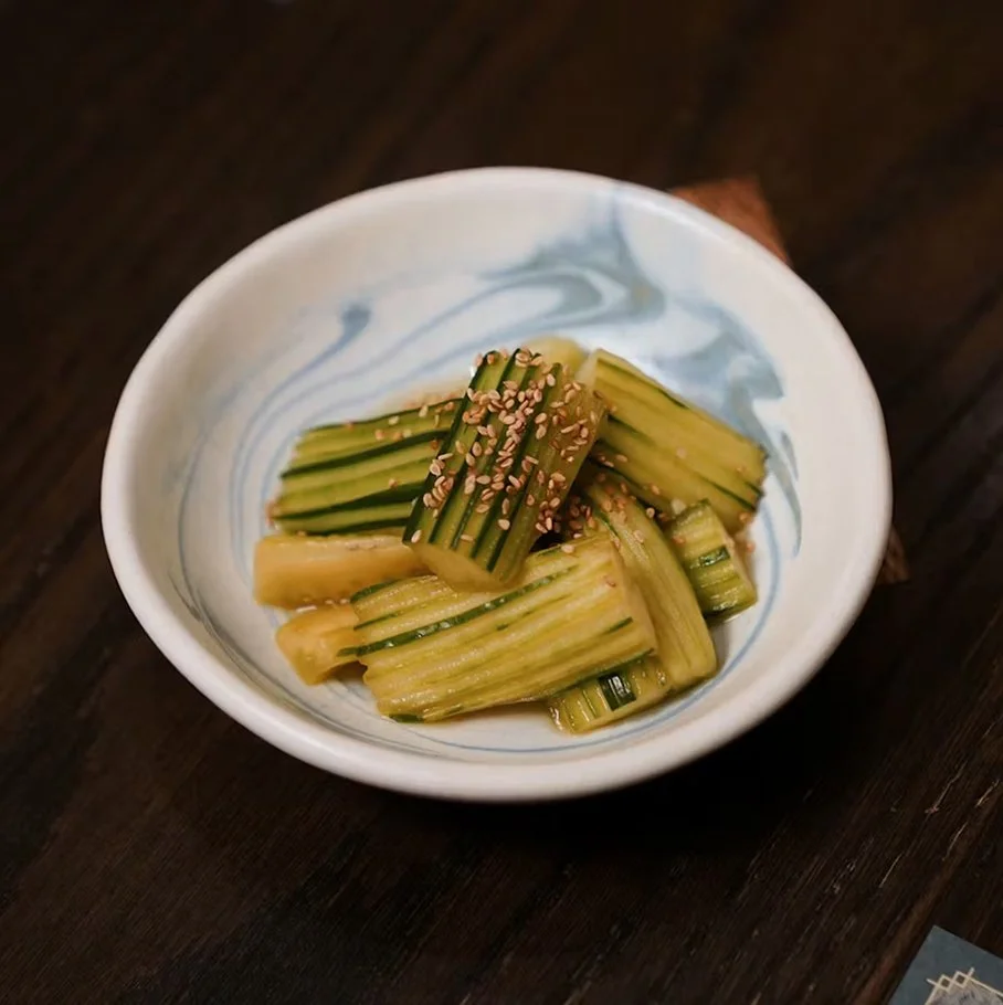 Cucumber salad — marinated cucumber sticks with soy sauce and rice vinegar, topped with sesame seeds