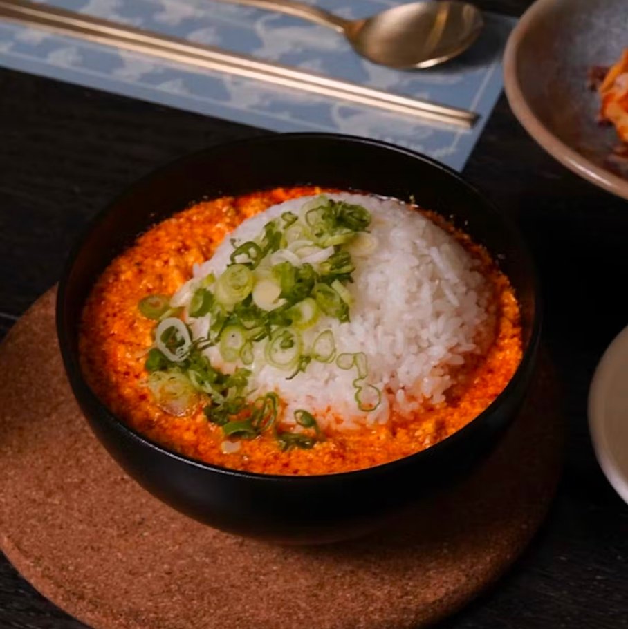 Spicy tofu gukbap — spicy pork tofu soup topped with scallions and served with rice