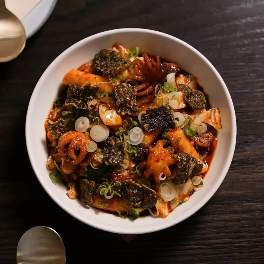 Octopus tteokbokki — stir-fried baby octopus, rice cakes, scallions, and vegetables in a spicy sauce