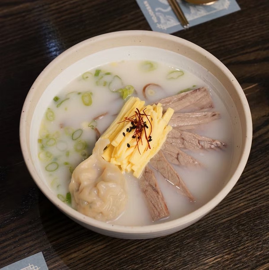 Gom-tang noodle soup — beef bone broth with buckwheat noodles, pork dumpling, short ribs, scallions, and egg