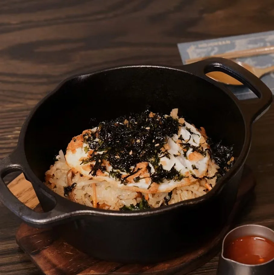 Wok-tossed bibimbap — wok-tossed vegetables and rice served in a cast-iron skillet with seasoned gochujang sauce