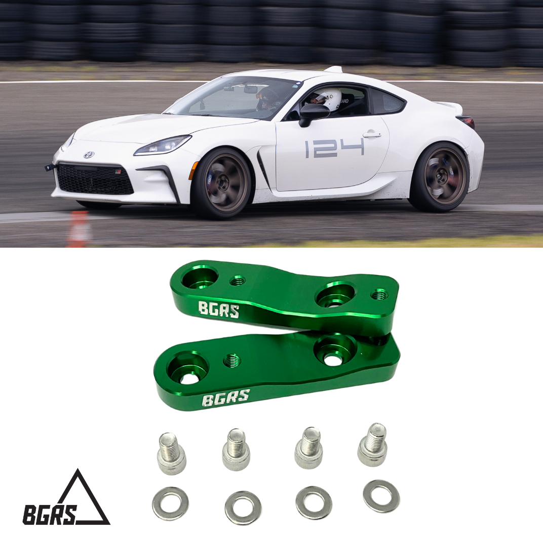 A white sports car racing on a track and green BGRS wheel spacers with mounting hardware below.