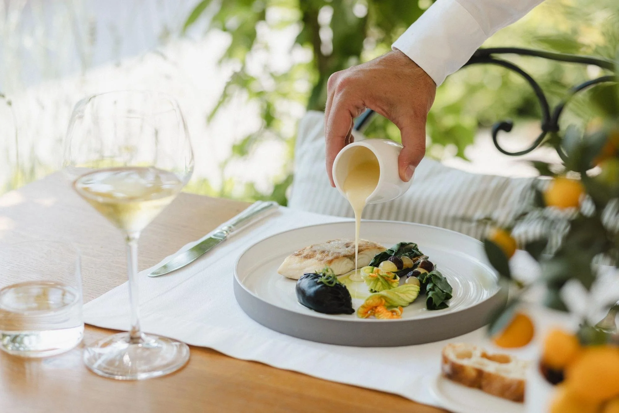 16-sauce-poured-over-a-plated-dish-at-an-outdoor-table.jpg