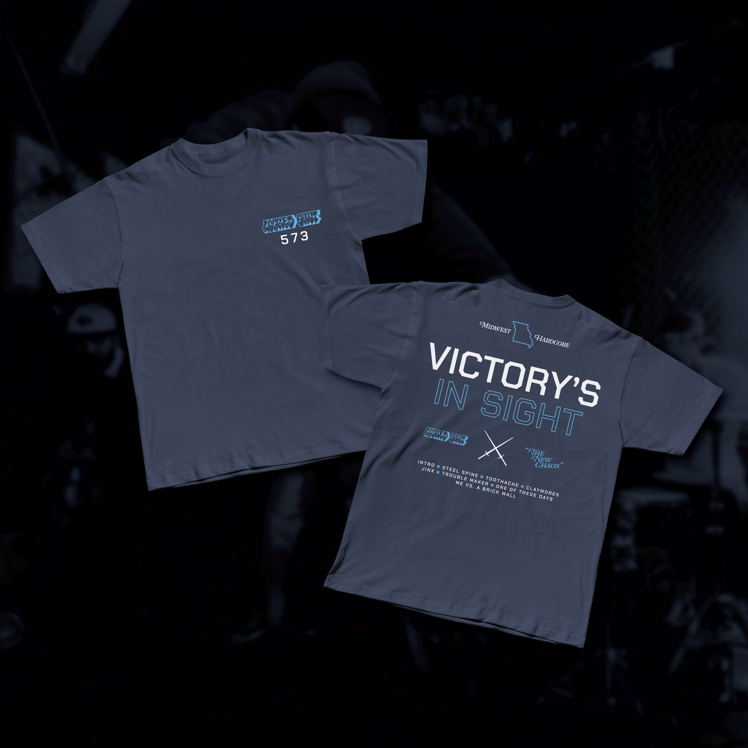 Two gray t-shirts featuring bold blue and white text and graphics for the band Locked Shut from Missouri, laid flat on a dark surface, with one shirt showing the front and the other showing the back design.