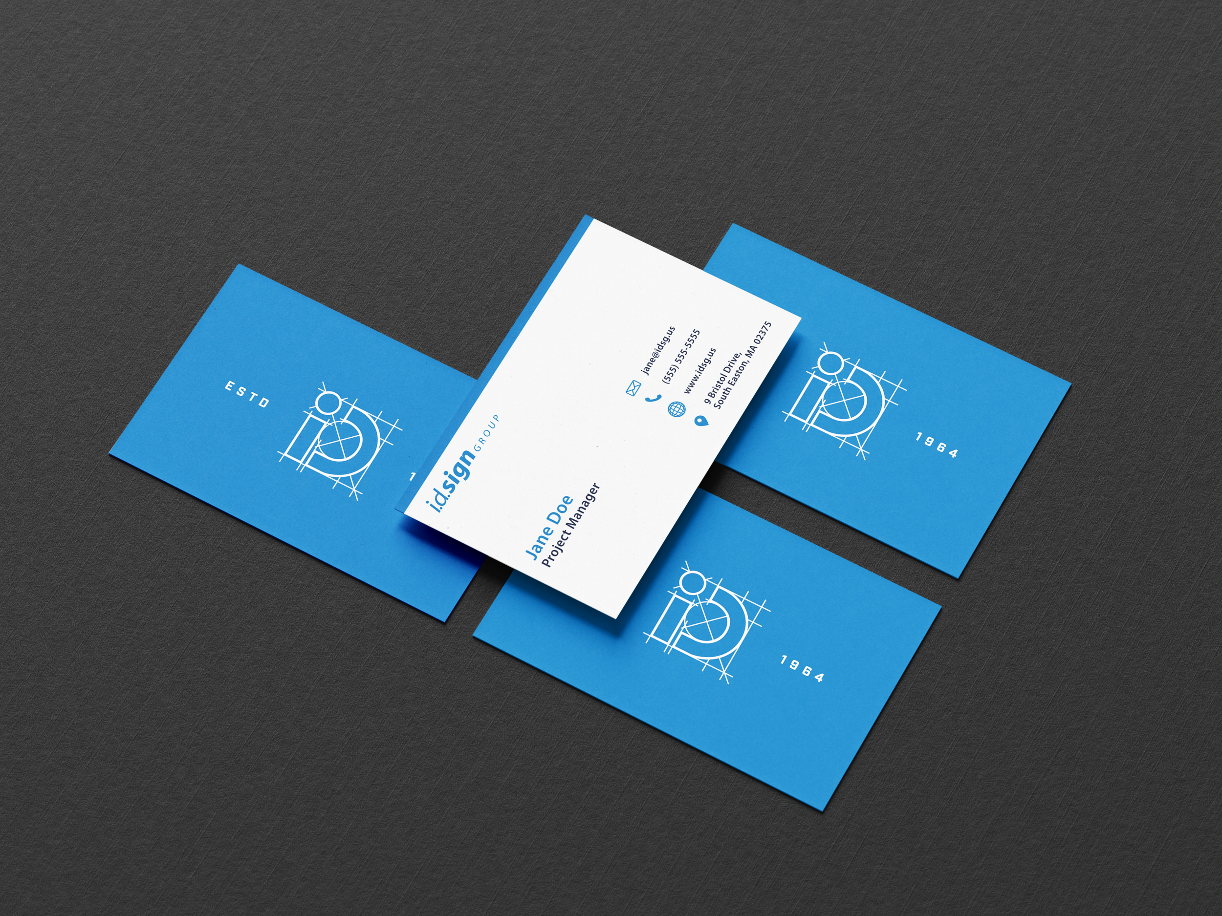 Business cards for ID Sign Group featuring blue background with white logo and details, with one card slightly lifted revealing contact information.