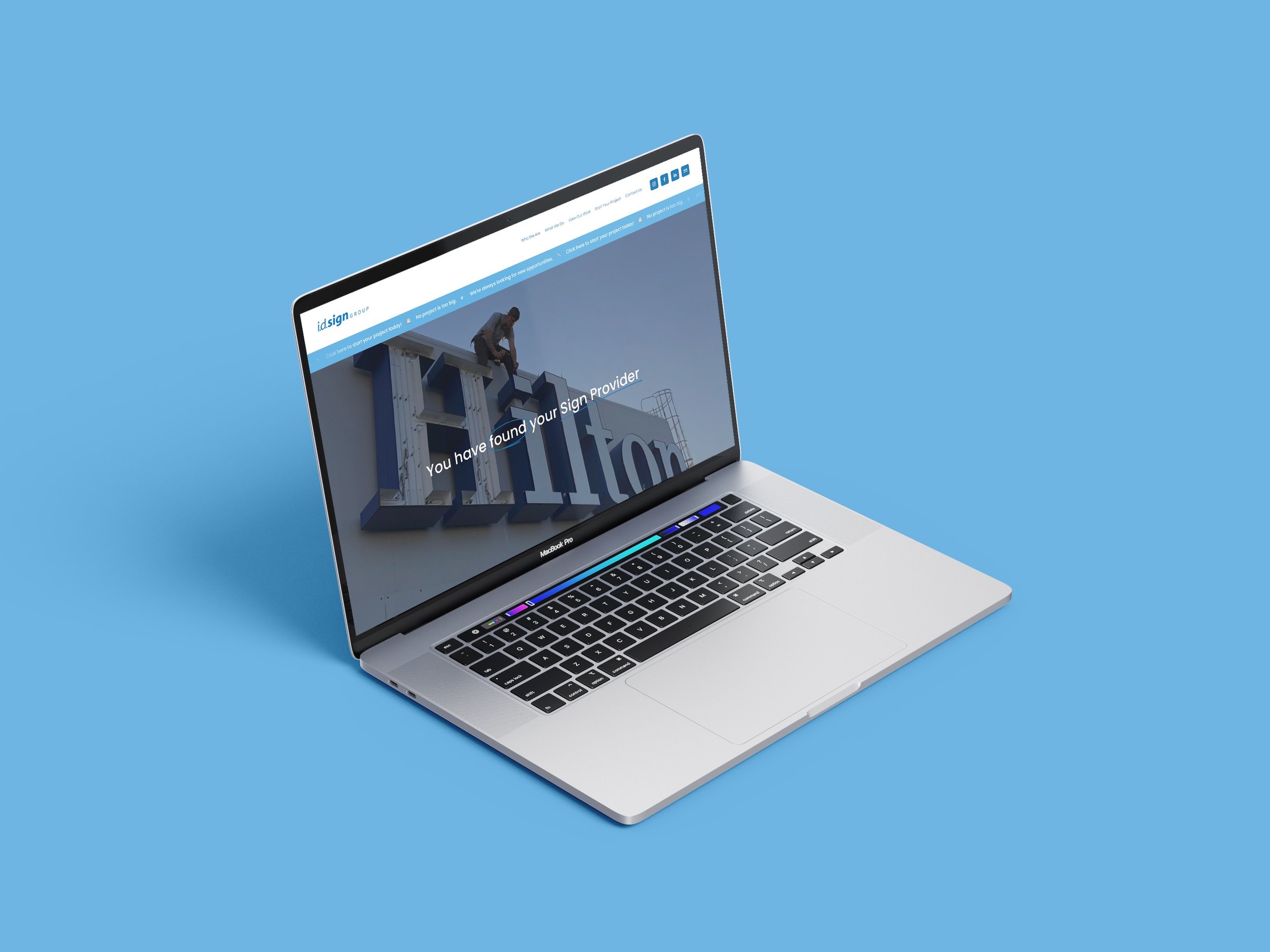 Open MacBook Pro laptop with a website about sign installation on a blue background.