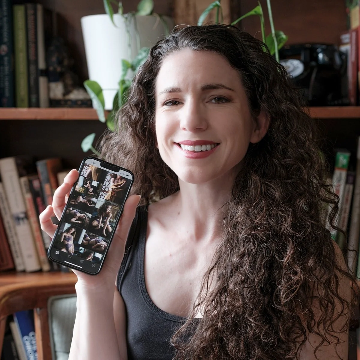 Woman showing her phone with her boudoir photos as digitals