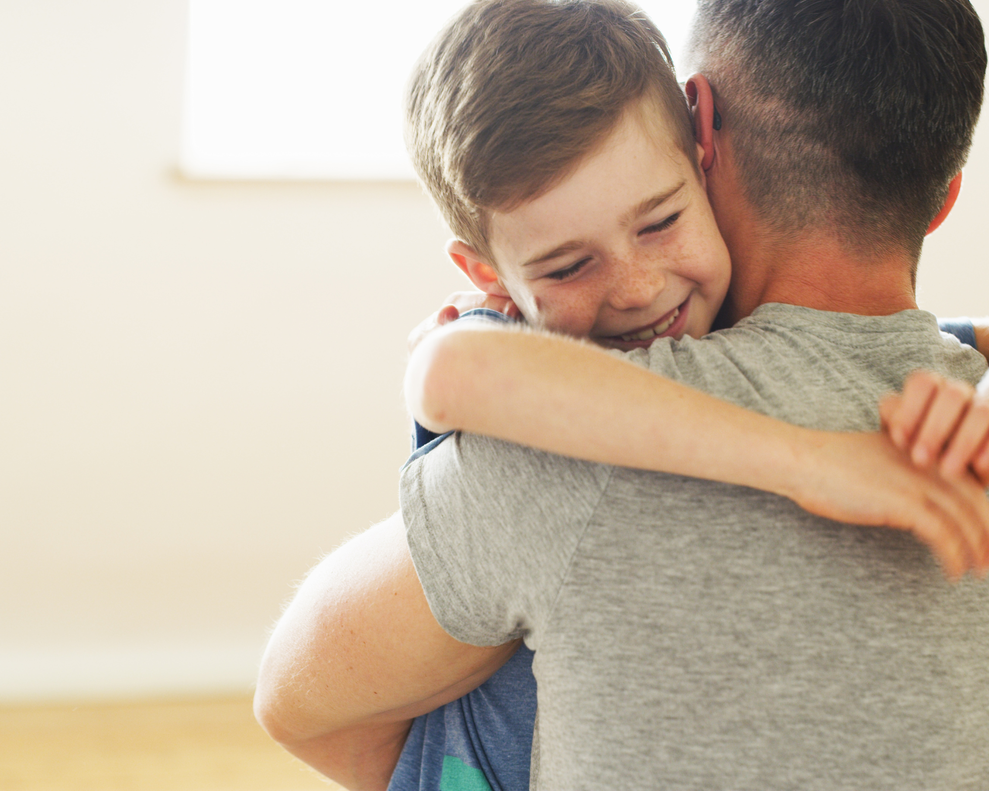 A remote worker and son embrace each other,.