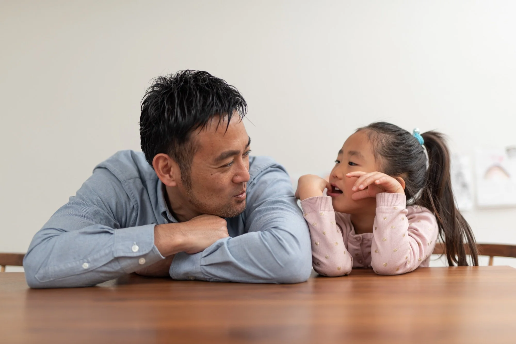 A parent and child talk at a table.