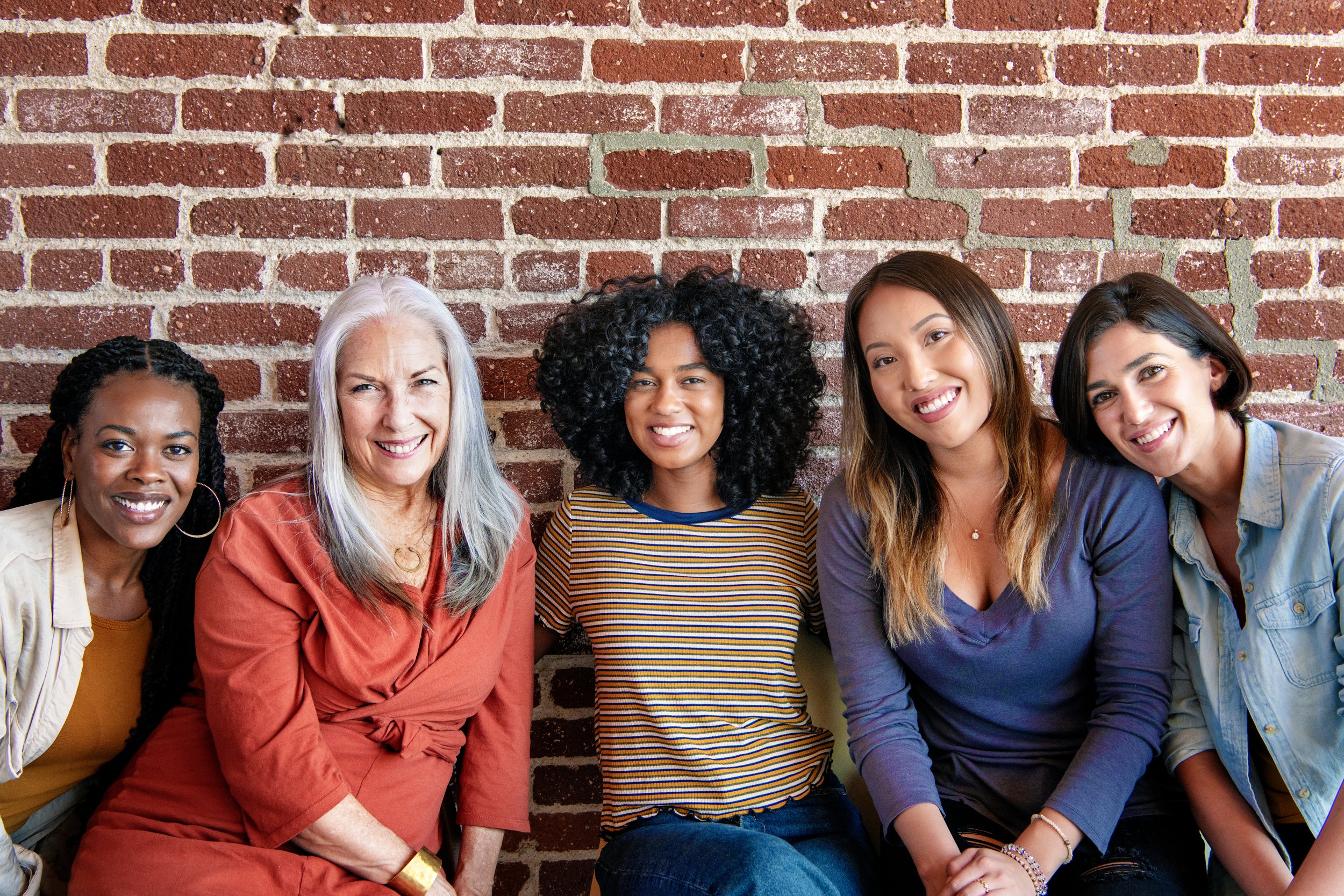 A group of women smile to the camera.