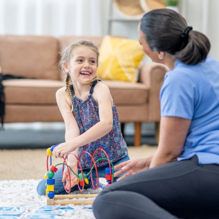 Woman and young girl playing happily indoors