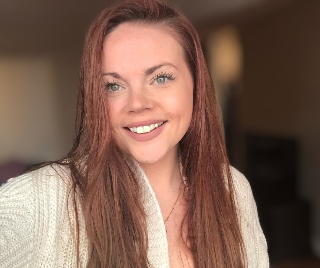 A woman with medium-light skin and long, auburn hair