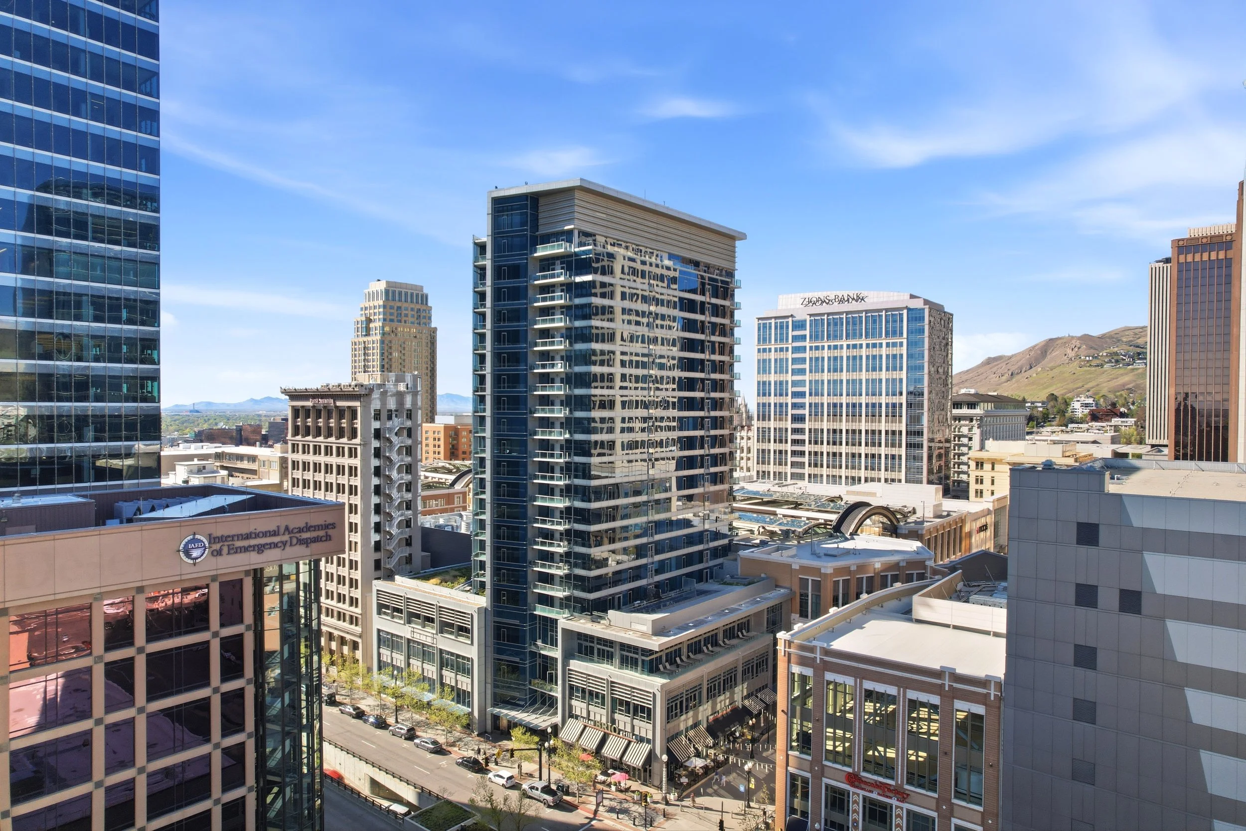Downtown Salt Lake City skyline view from a luxury high-rise apartment overlooking City Creek and the surrounding mountains.