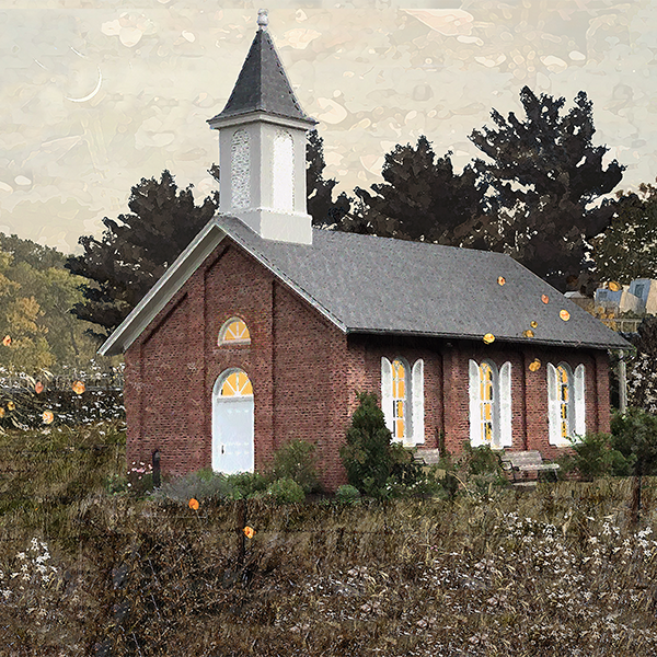 A small red brick church with a white steeple, surrounded by trees and bushes, under an overcast sky.