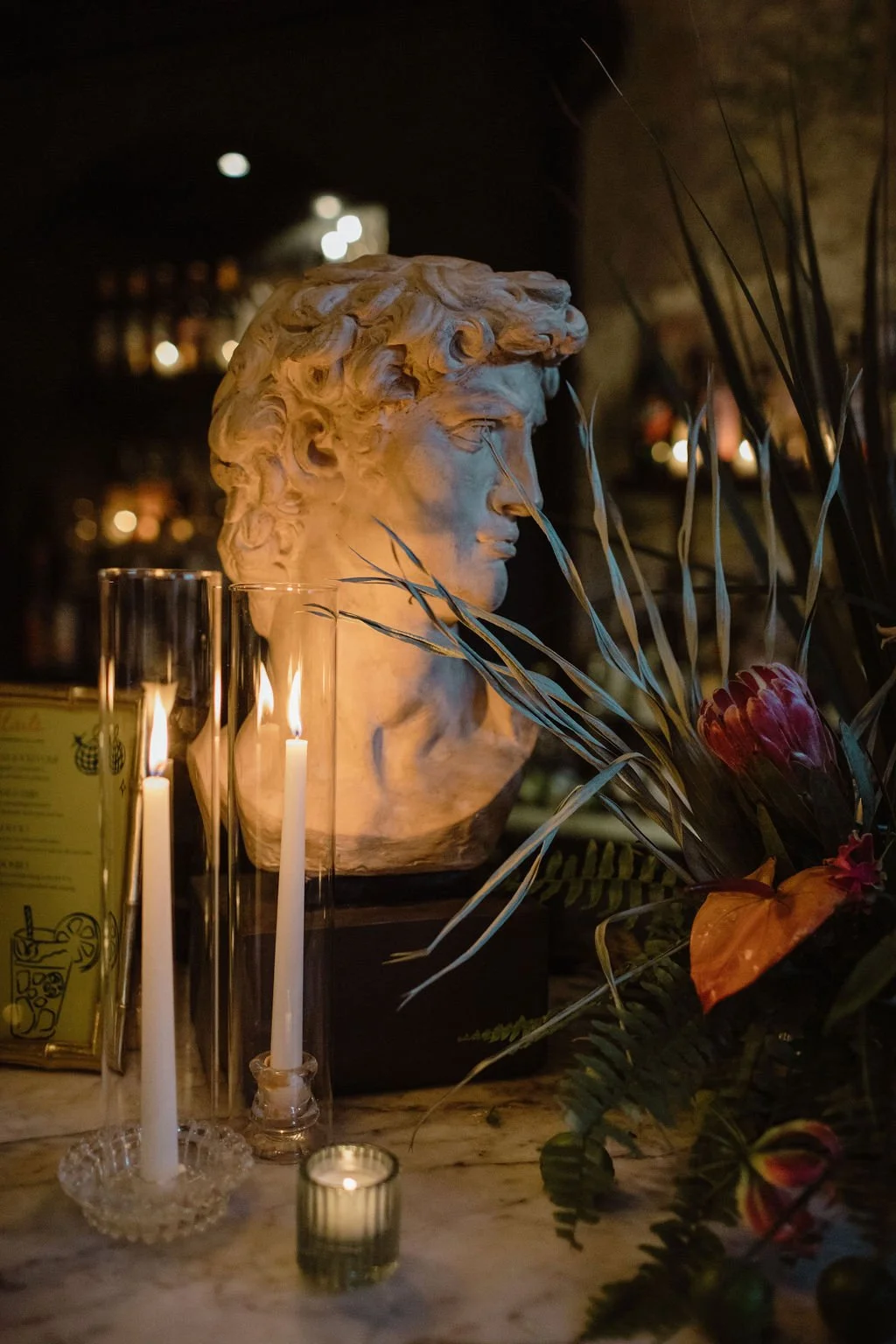 statue of a man and candles and fruit and flowers