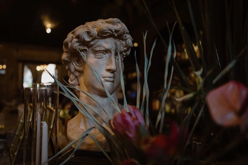 statue on the bar with flowers in front