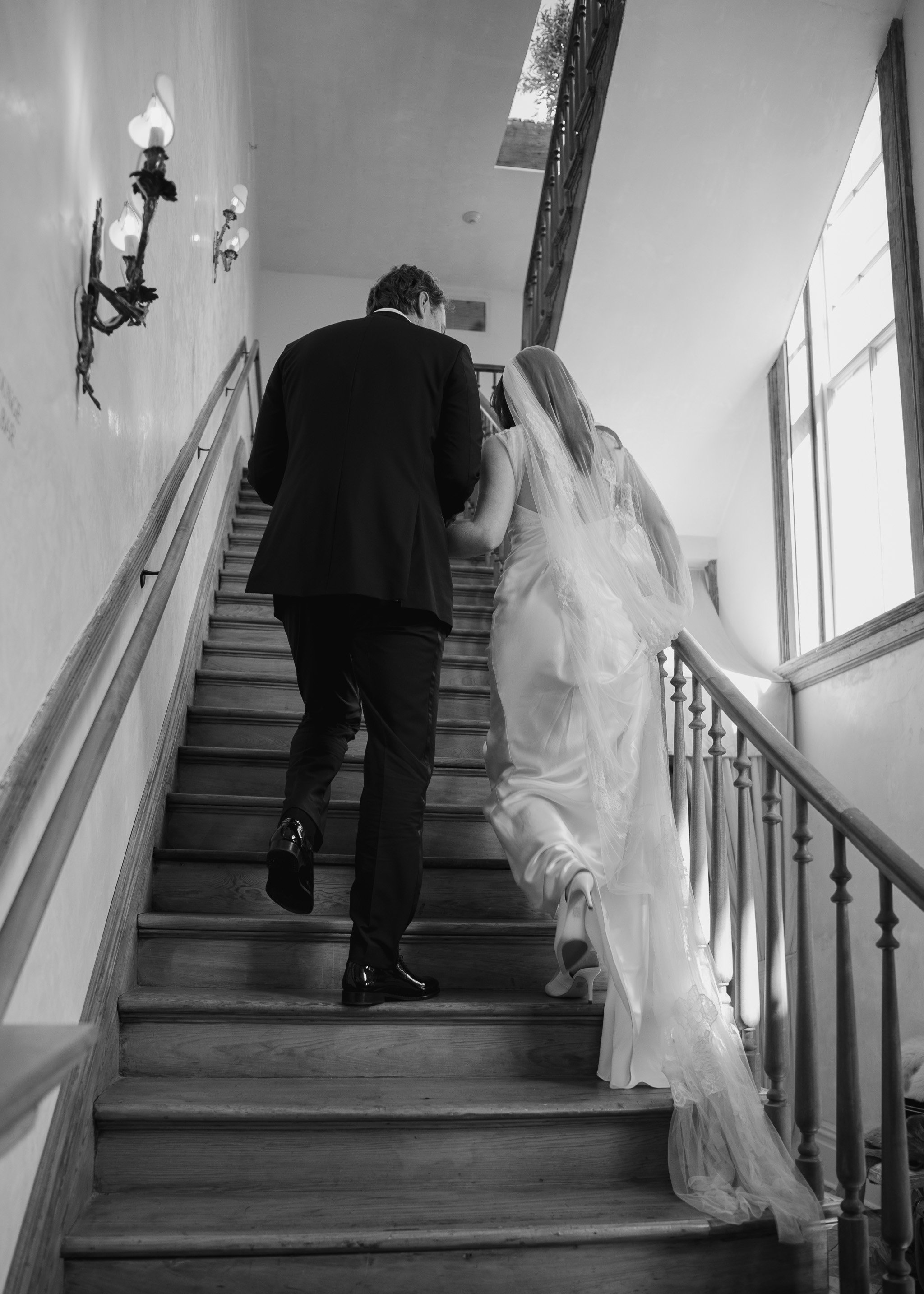 Walking up the stairs in wedding dress and veil at hotel peter and paul