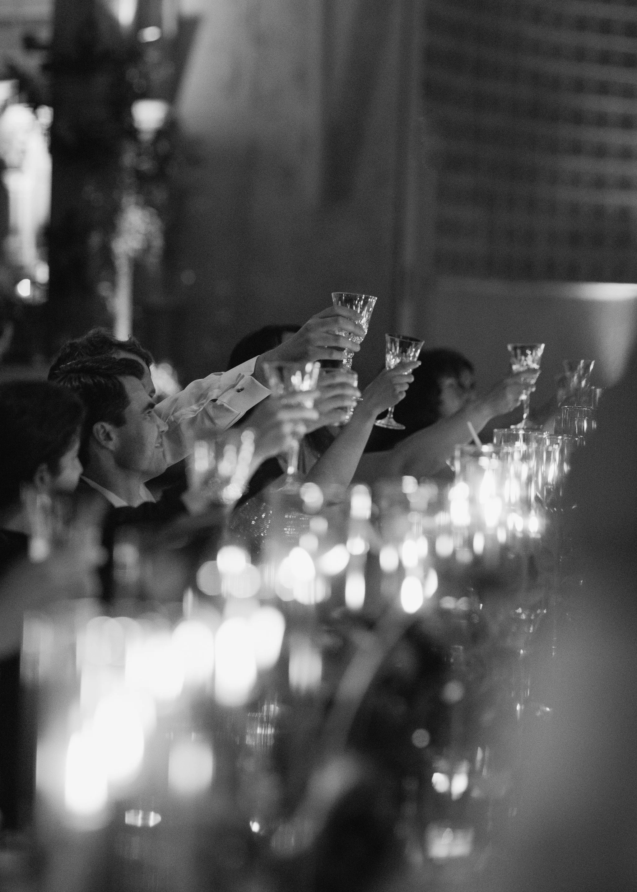 hands toasting wine glasses during dinner