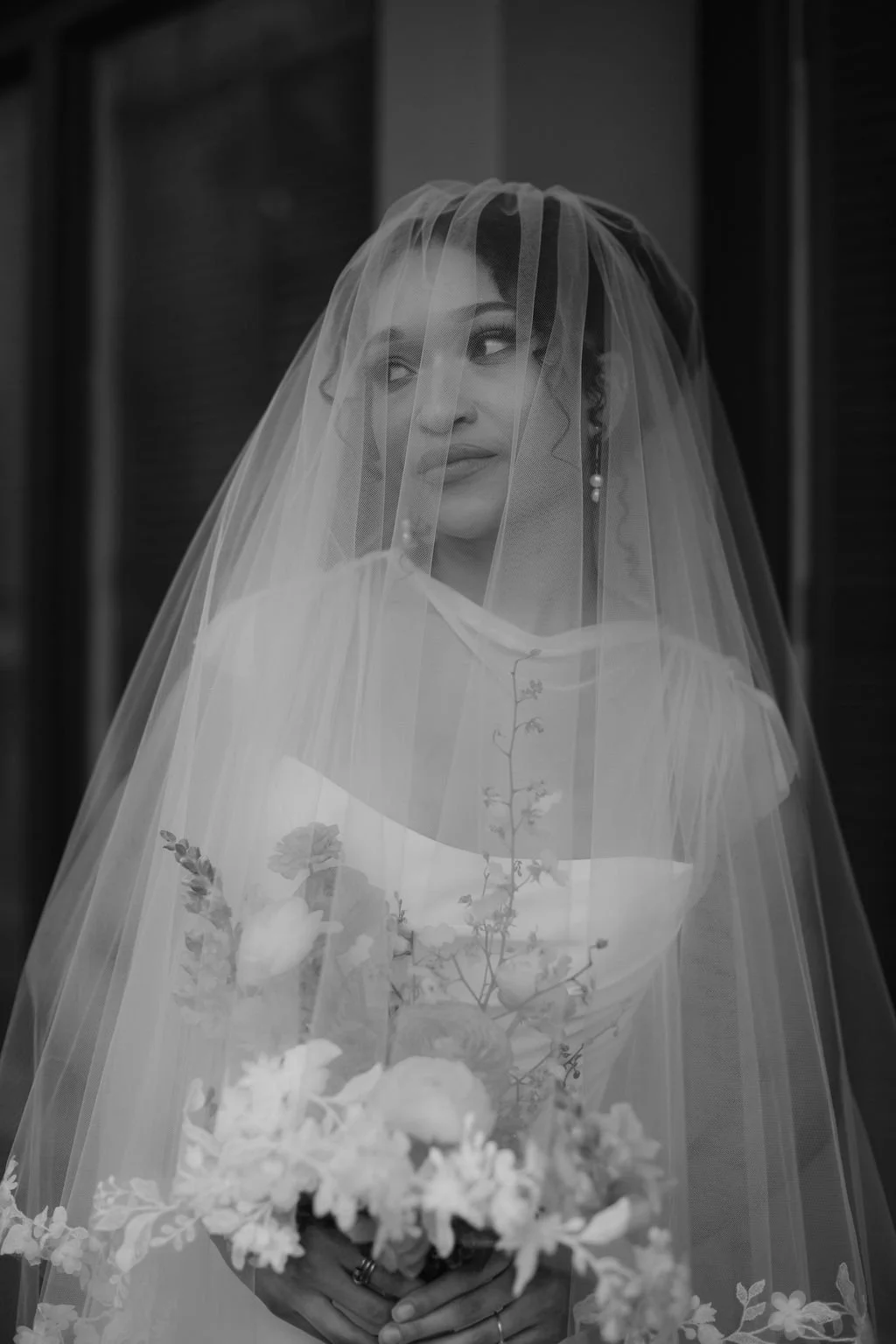 Bride wearing a veil and holding a bouquet