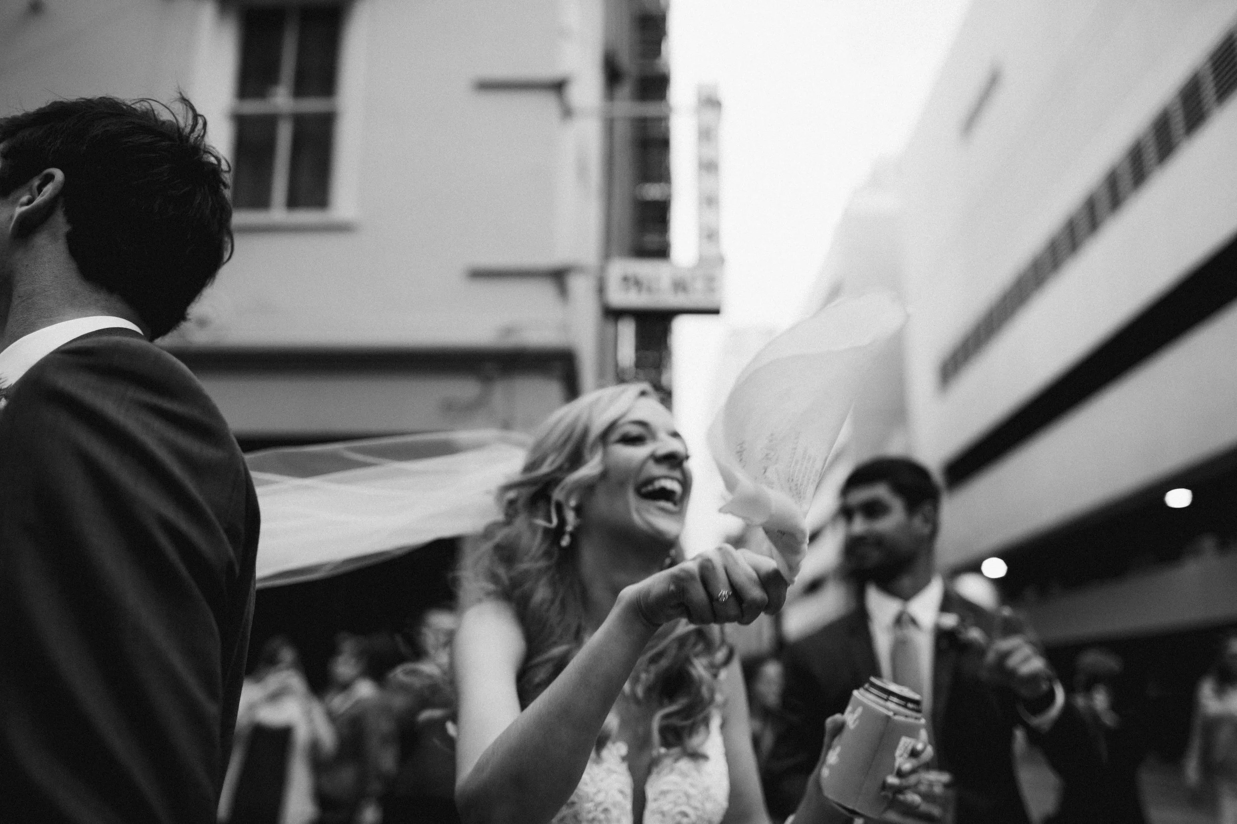 Bride waves a scarf in the street wearing a veil