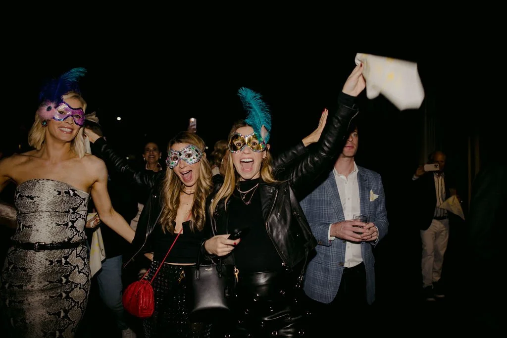 women wearing teal and pink mardi gras masks
