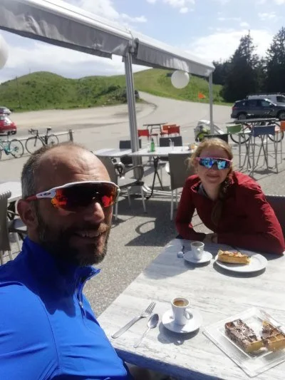 Two cyclists at cafe drinking coffee on cycling holiday