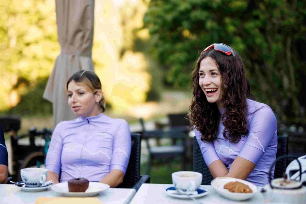 Two cyclists enjoying coffee and cake during a bike ride cycling holiday